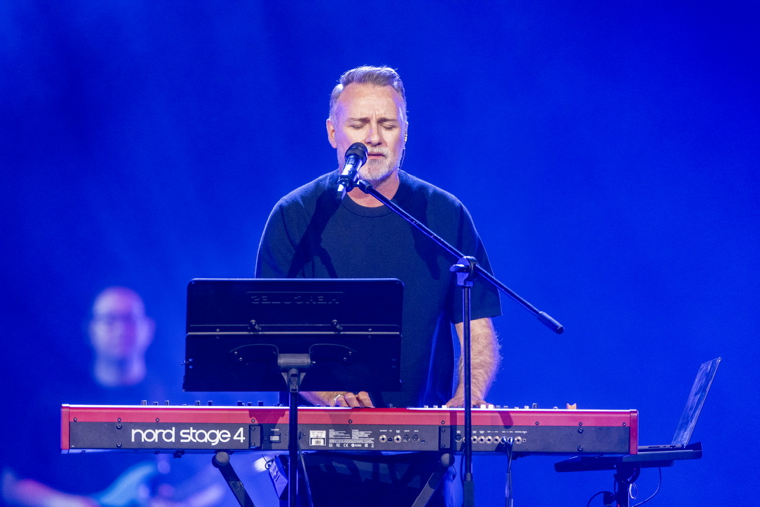 Mark Stevens singing and playing the keyboard during worship